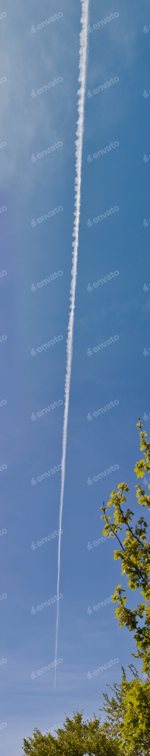 Preview: Airplane Flying In A Blue Sky With A Very Long Trail Of Gases And Chemicals Floating Behind It