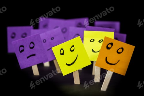 Preview: Conceptual Image Using Sticky Notes With Hand Drawn Faces On Them Isolated On A Black Background