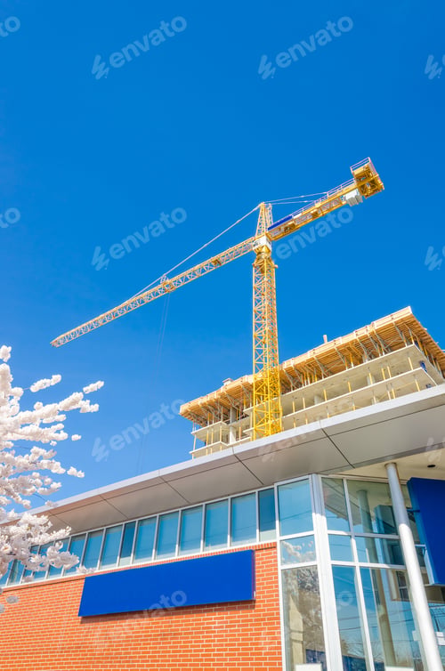 Preview: High-Rise Building Under Construction. The Site With Cranes Against Blue Sky