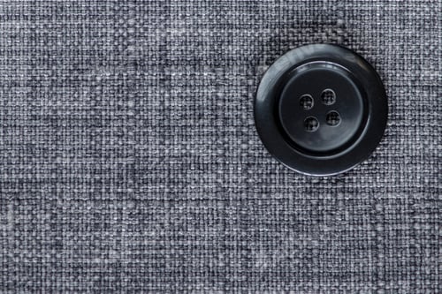 Preview: Clothes Sewing Button On A Gray Fabric Swatch Background