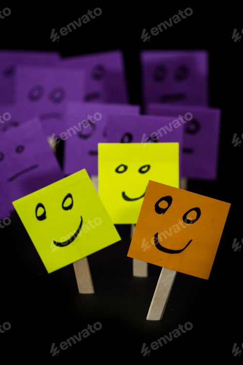 Preview: Conceptual Image Using Sticky Notes With Hand Drawn Faces On Them Isolated On A Black Background