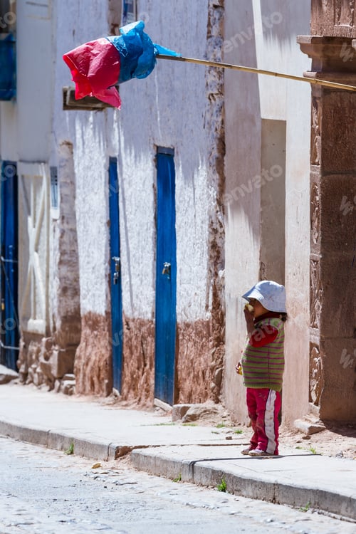 Preview: Maras Peru -May 18 : Young Boy Standing Outside Of His Door Eating Fresh Fruit With A Traditional
