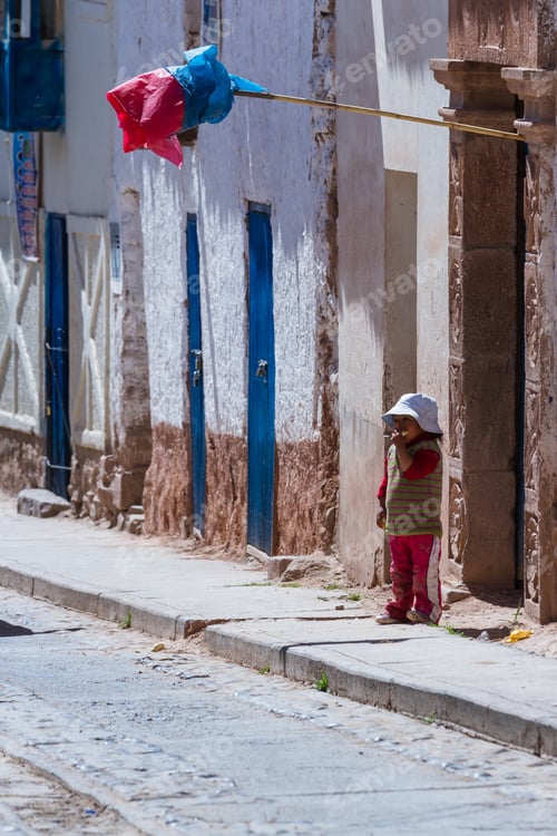 Preview: Maras Peru -May 18 : Young Boy Standing Outside Of His Door Eating Fresh Fruit With A Traditional