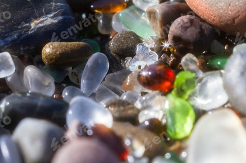 Preview: Close Up Of A Group Of Shiny Pieces Of Sea Glass On The Beach Using A Star Filter To Obtain A