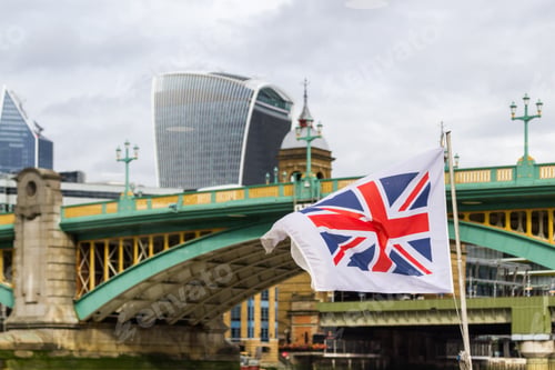 Preview: London - September 06 2019: Crossing Under The London Bridge With A Uk Flag Waving In The Wind