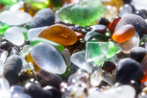 Preview: Close Up Of A Group Of Shiny Pieces Of Sea Glass On The Beach Using A Star Filter To Obtain A