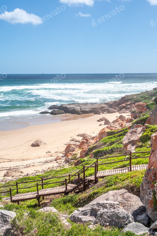 Preview: Portrait Photo Of A Boardwalk With Handrails Going Down To A Deserted Beach On A Sunny Afternoon