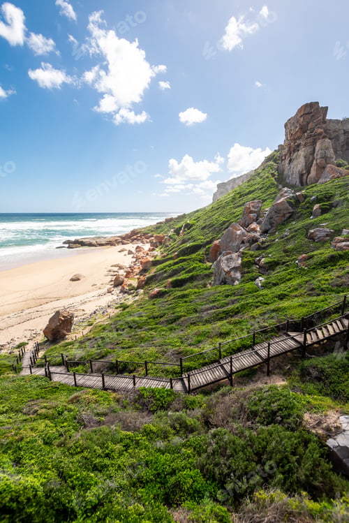 Preview: Portrait Photo Of A Boardwalk With Handrails Going Down To A Deserted Beach On A Sunny Afternoon