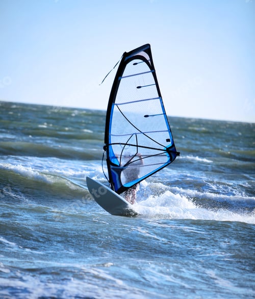 Preview: Lone Anonymous Windsurfer In The Ocean Catching A Wave