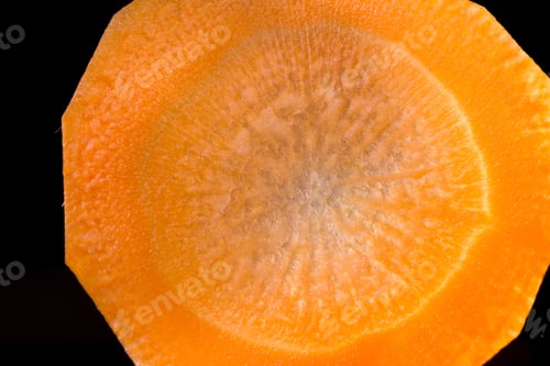 Preview: Close Up Of A Thin Slice Of Carrot Back Lit With A Beautiful Pattern And Glowing Orange Color