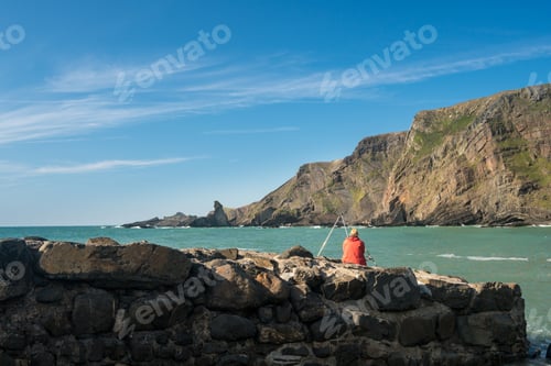Preview: Man Fishing In The Ocean At Hartland Quay In North Devon, England