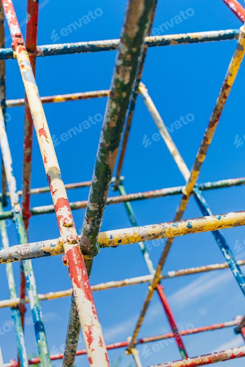 Preview: Old Rusty Playground Equipment Jungle Gym With Peeling Paint Against A Blue Sky Selective Focus