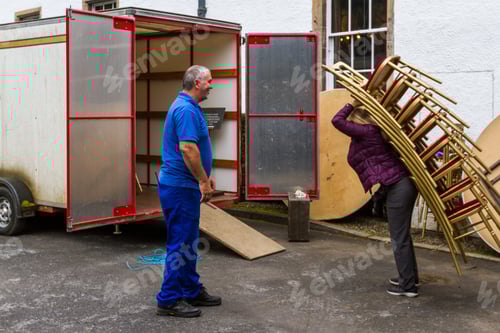 Preview: Pitlochry Scotland - September 12 2019: Man Teasing A Tourist How To Load Chairs Into A Truck From