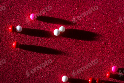 Preview: Macro Of A Group Of Small Edible Sugar Sprinkles With Long Shadows As A Conceptual Background