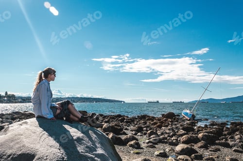 Preview: Photo Of Girl Sitting On A Rock At Kitsilano Beach In Vancouver, Canada