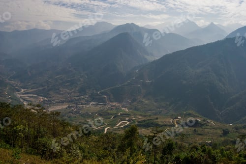 Vista previa: Terrazas de arrozales con hermosas montañas en el fondo. Pueblo en la parte inferior del