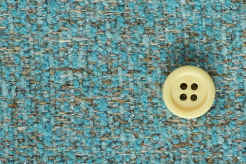 Preview: Clothes Sewing Button On A Turquoise Fabric Swatch Background