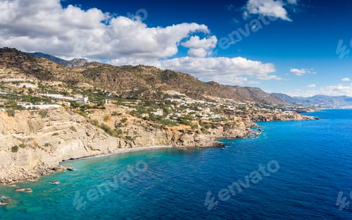 Preview: Scenics View Of Idyllic Blue Sea Near The Rocky Mountain Landscape With Fluffy Clouds In Sky