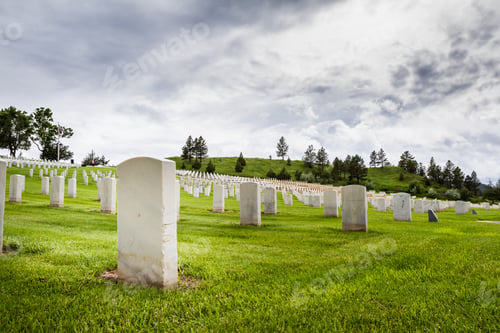 Preview: Rows Of Tombstones In A Military Graveyard With Bright Green Spring Grass And Dramatic Storm Clouds
