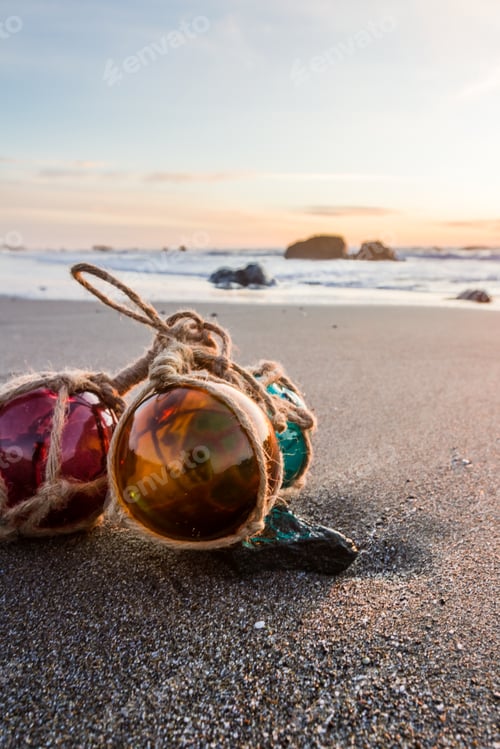 Preview: Sunset In The Oregon Coast With Colorful Glass Floats On A A Sandy Beach