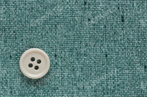 Preview: Clothes Sewing Button On A Turquoise Fabric Swatch Background
