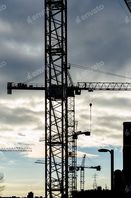 Preview: Construction Site With Cranes At Sunset, Sunrise, Dawn Time With The Cranes As A Silhouette