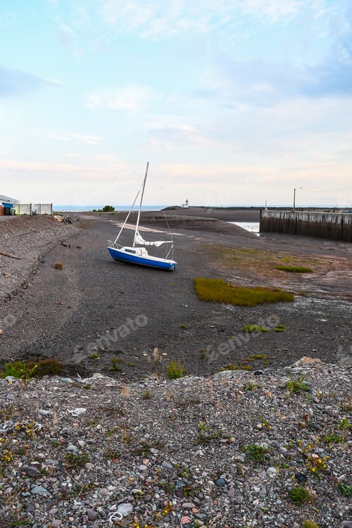 Preview: A Grounded Sailboat At Low Tide In The Bay Of Fundy With The Parrsboro Lighthouse