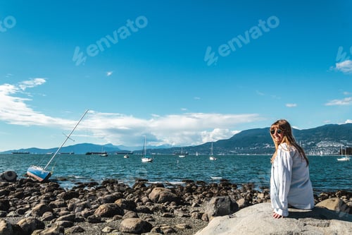Preview: Photo Of Girl Sitting On A Rock At Kitsilano Beach In Vancouver, Canada