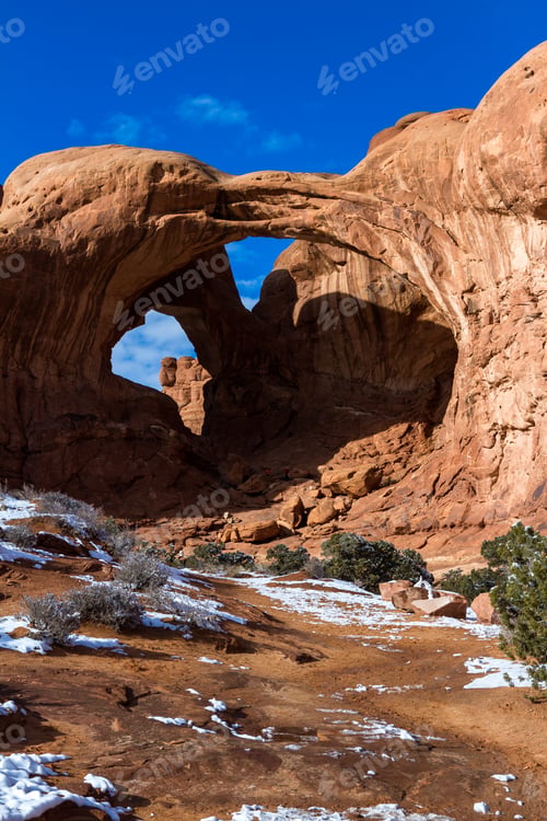 Preview: Double Arch With A Bit Of Snow In The Ground And People Under The Arch Giving It Proper Size