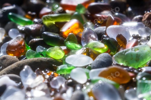 Preview: Close Up Of A Group Of Shiny Pieces Of Sea Glass On The Beach Using A Star Filter To Obtain A