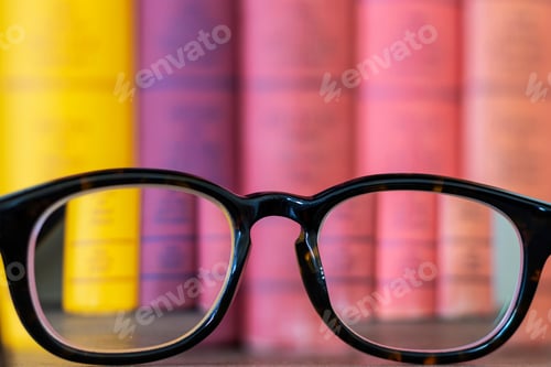 Preview: Prescription Eyeglasses In Focus With Blurry Book In Background Selective Focus