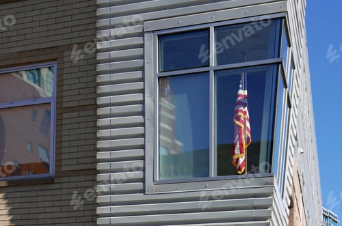 Preview: American Flag In An Apartment Behind A Corner Window Of A Modern Building