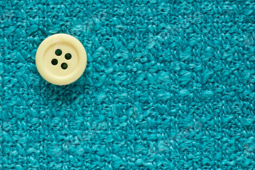Preview: Clothes Sewing Button On A Turquoise Fabric Swatch Background