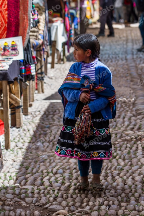 Preview: Pisac, Peru - May 15: Adorable Native Quechua Girl Walking The Alleyways Selling Hand Made