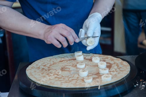 Preview: Hands Cutting Banana For Banana Crepe On The Griddle