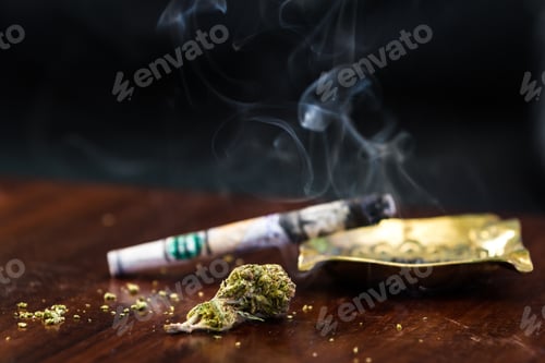 Preview: Close Up Of A One Hundred Dollar Bill Joint With Smoke On One End In A Dark Room