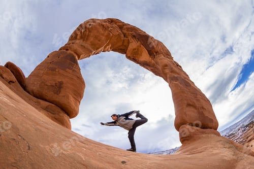 Preview: Man Unsuccessfully Trying To Do A Balancing Pose At The Base Of Delicate Arch