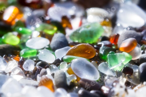 Preview: Close Up Of A Group Of Shiny Pieces Of Sea Glass On The Beach Using A Star Filter To Obtain A
