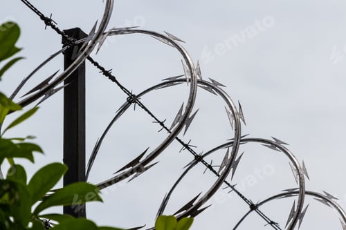 Preview: Razor And Barbed Wire With A Cloudy Sky In The Background
