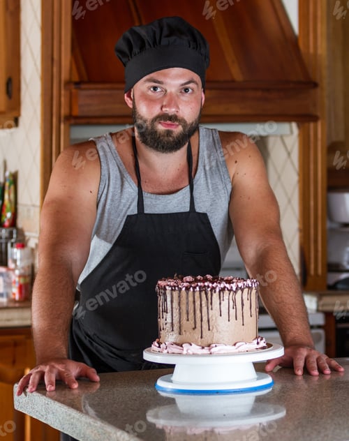 Preview: Young Pastry Chef In His Home Kitchen Presenting A Just Made And Decorated Birthday Cake With