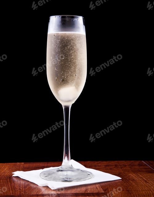 Preview: Champagne Flute Served With Sparkling Wine And A Sugar Cube Isolated On A Black Background