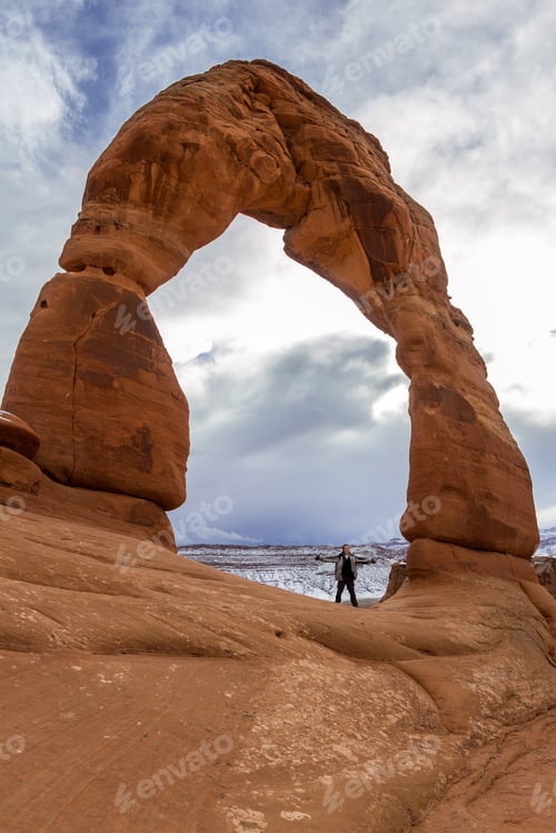 Preview: Man Standing At The Base Of Delicate Arch Giving A Better Size Comparison Of This Beautiful Feature