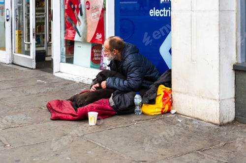 Preview: London - September 05 2019: Homeless Man With His Dog With People Walking Past On The Sidewalk