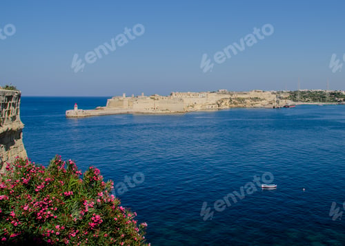 Preview: Scenic View Of An Isolated Small Boat In The Harbor In Valletta, Malta With The Lighthouse And