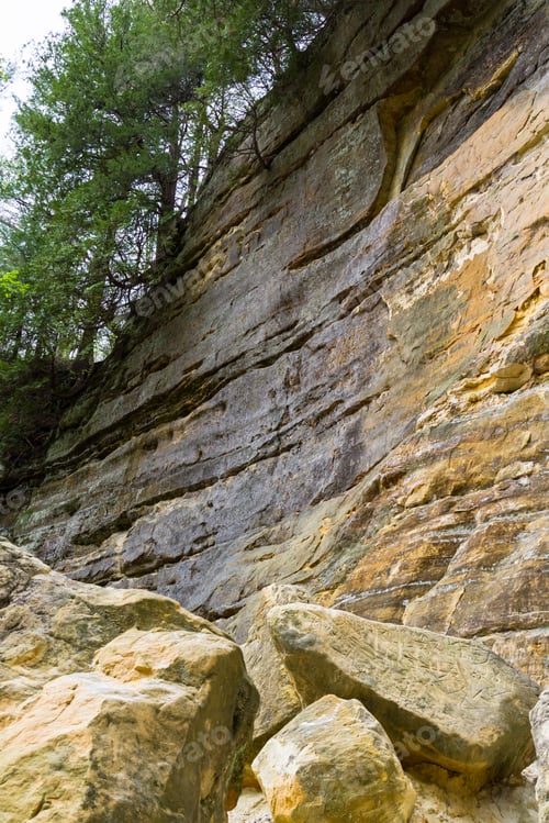 Preview: Large Sandstone Cliffs With Rocks That Have Fallen In The Past Turning Into Powder On The Ground