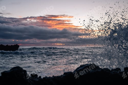Preview: Waves Splashing Against The Rocks On The Shore In The Early Morning With The Sun Peaking Through