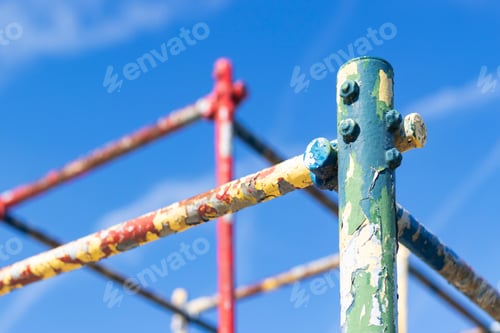 Preview: Old Rusty Playground Equipment Jungle Gym With Peeling Paint Against A Blue Sky Selective Focus