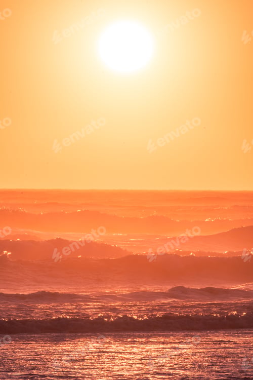 Preview: Portrait Photo Of The Sun Clearly Defined Setting On The Ocean. Waves, Beach And Reflection In The