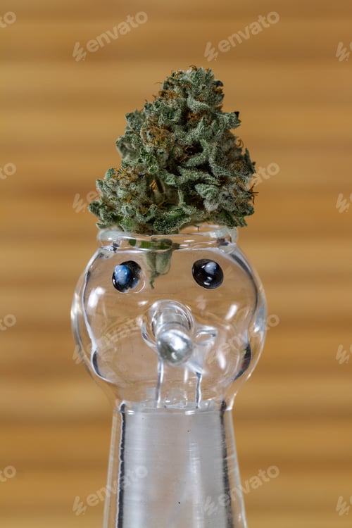 Preview: Close Up Of A Cannabis Bud On Top Of A Smoking Device With Eyes And A Face