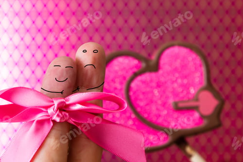 Preview: Love Concept With Two Fingers With Faces Over A Pink Patter Background